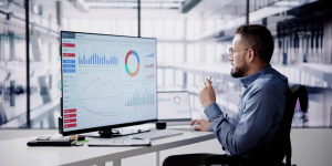 IT professionals reviewing cloud infrastructure data on multiple screens during a systems management meeting